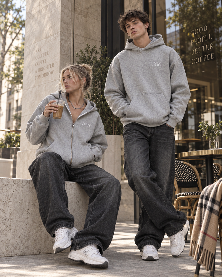 Two models in the grey Heritage Zip Up and Pullover outside a café